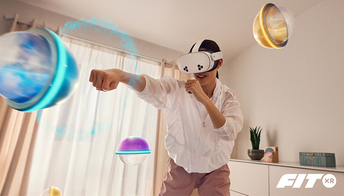 Ragazza con visore VR che boxa verso un cerchio blu virtuale. Altri cerchi virtuali colorati fluttuano nell'area.