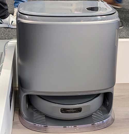 Dispositivo cilindrico grigio con base trasparente, alloggiamento interno per un robot aspirapolvere rotondo.
