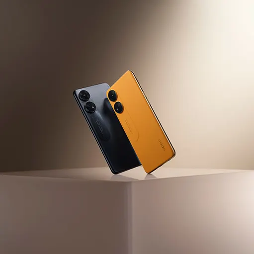 Due telefoni cellulari appoggiati su una superficie chiara. Uno � nero con due obiettivi circolari, l'altro � arancione.
