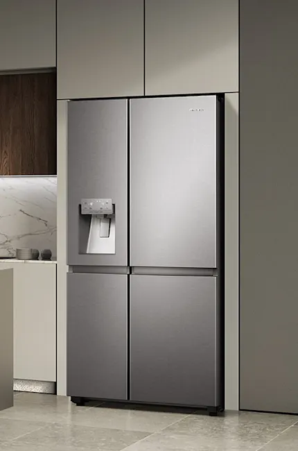 Frigorifero a quattro porte in metallo in cucina moderna con armadietti grigi e pavimento piastrellato.