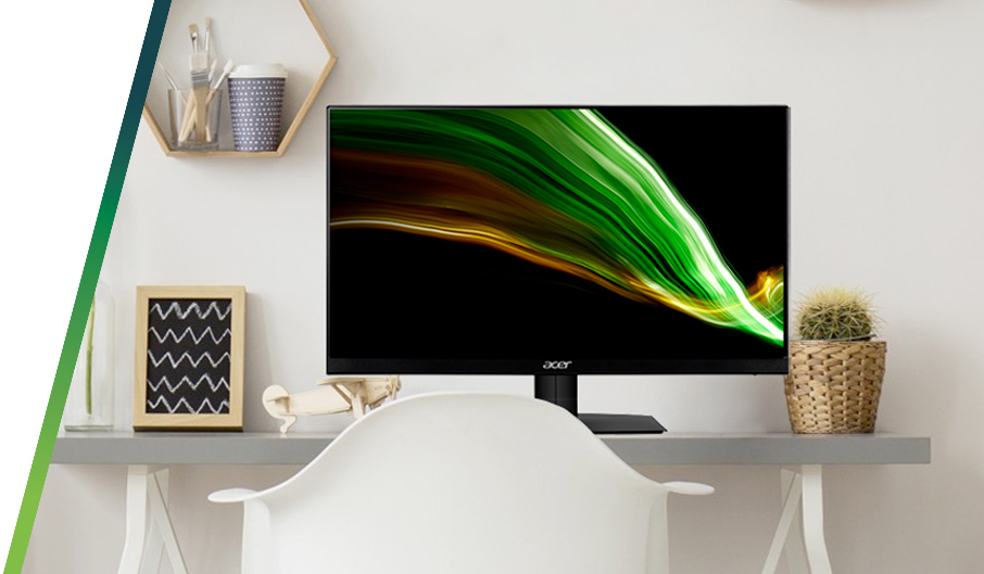 Scrivania con monitor Acer acceso che mostra un'immagine astratta verde e oro. Sopra, una mensola esagonale e un cactus in vaso.