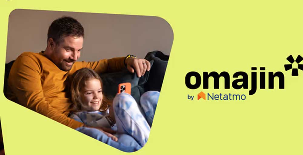 Padre e figlia sorridono su un divano. L'uomo indossa una maglia arancione. Logo "Omajin by Netatmo" su sfondo giallo.