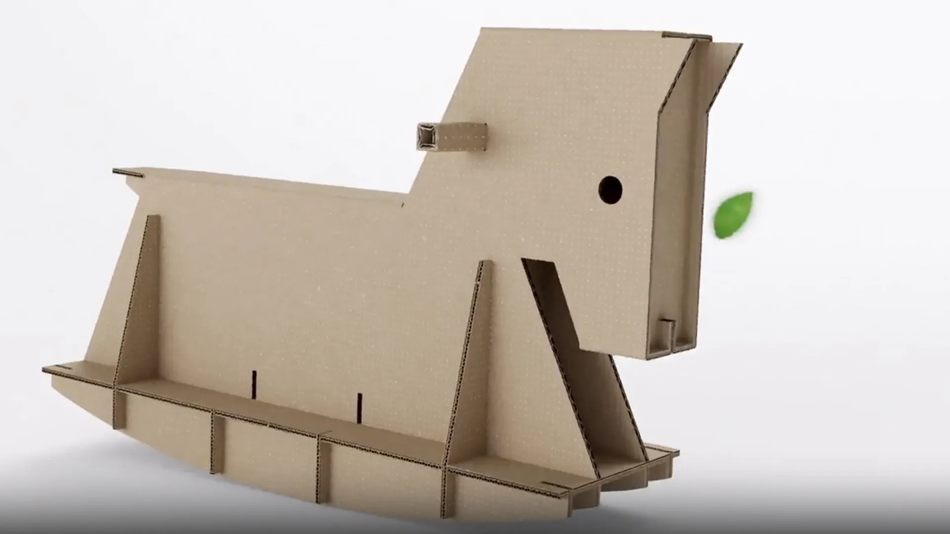 Cavallo a dondolo di cartone su sfondo bianco, con foglia verde vicino alla testa.