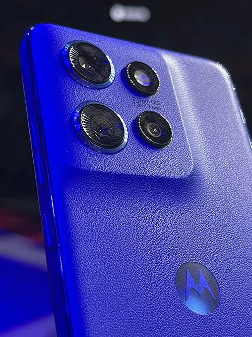 Retro di un telefono blu con quattro obiettivi circolari della fotocamera e logo.