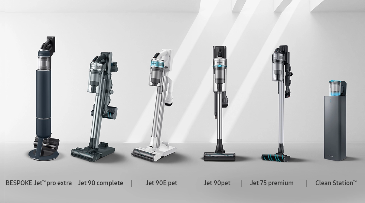 In mostra sei aspirapolveri verticali di diversi modelli e colori su uno sfondo bianco.