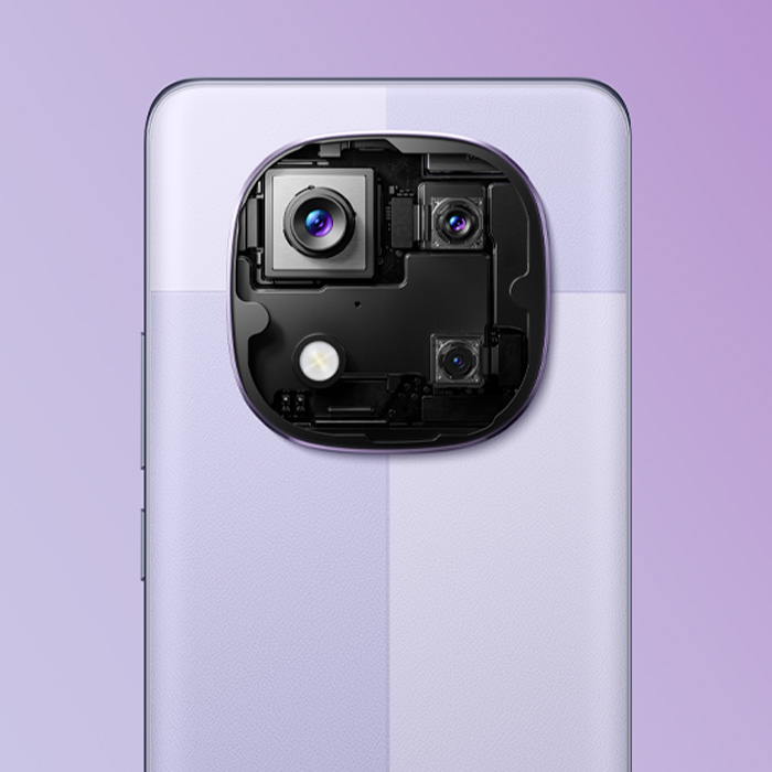 Vista posteriore di un telefono con fotocamera a tre obiettivi e flash su sfondo viola chiaro.