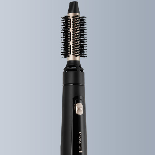 Spazzola elettrica nera con setole cilindriche, marchio "Remington" visibile sul corpo, su sfondo grigio.