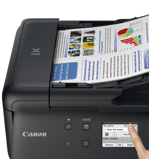 Stampante Canon nera con un foglio di carta stampato. Un dito tocca lo schermo della stampante.