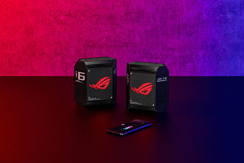 Due scatole nere con logo rosso e un telefono su una superficie scura. Sfondo rosso e blu.