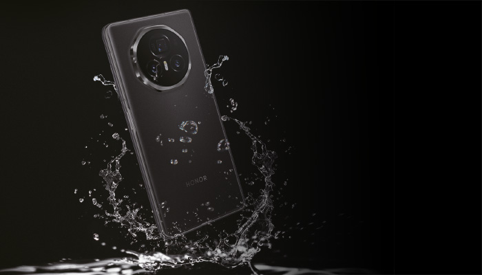 Un telefono nero con una fotocamera circolare è circondato da spruzzi d'acqua su uno sfondo nero.