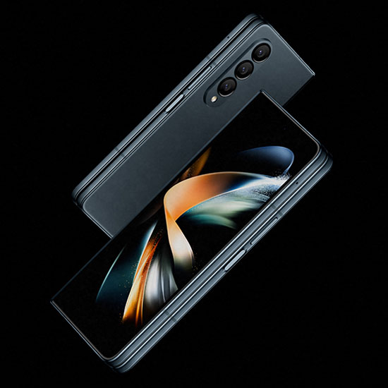 Due telefoni grigi su sfondo nero. Uno mostra uno schermo con motivi astratti arancioni, bianchi e blu. L'altro ha tre obiettivi della fotocamera.