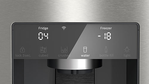 Display digitale del frigorifero mostra "Fridge 04" e "Freezer -18" con icone per acqua e altre funzioni.