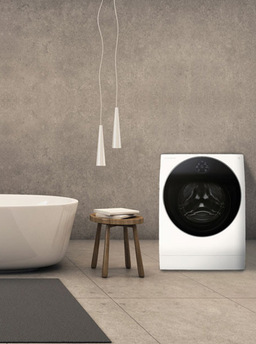 Bagno con vasca bianca, sgabello in legno con libro, lavatrice bianca con obl� nero e lampade a sospensione.