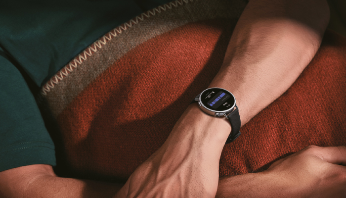 braccio di un uomo in maglietta verda che ha al poslo un orologio xiaomi nero