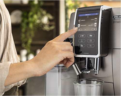 Una persona preme lo schermo di una macchina da caff� DeLonghi sopra un bicchiere trasparente.