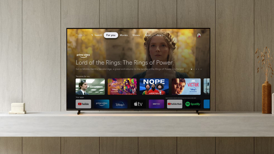 Schermo TV su mobile bianco con app di streaming e "Il Signore degli Anelli: Gli Anelli del Potere" di Prime Video.