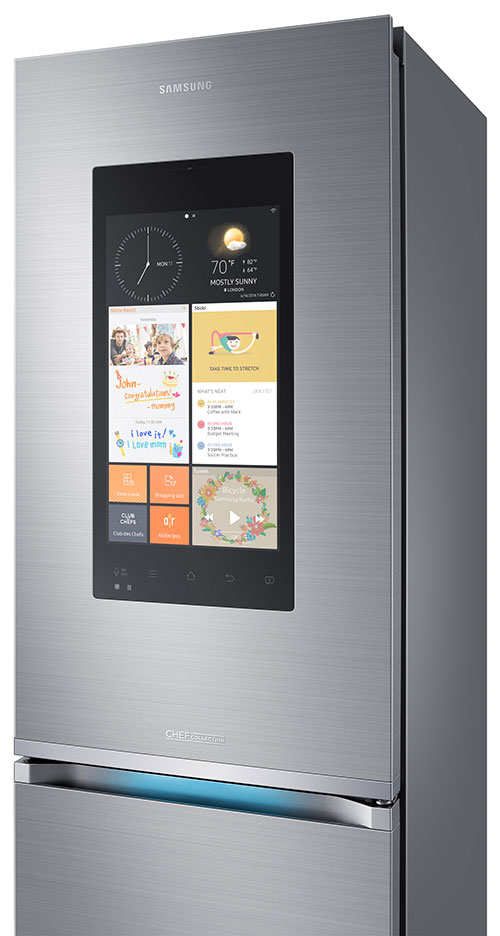 Frigorifero Samsung in acciaio con schermo touch che mostra orologio, meteo e varie app. Maniglia orizzontale con luce azzurra.
