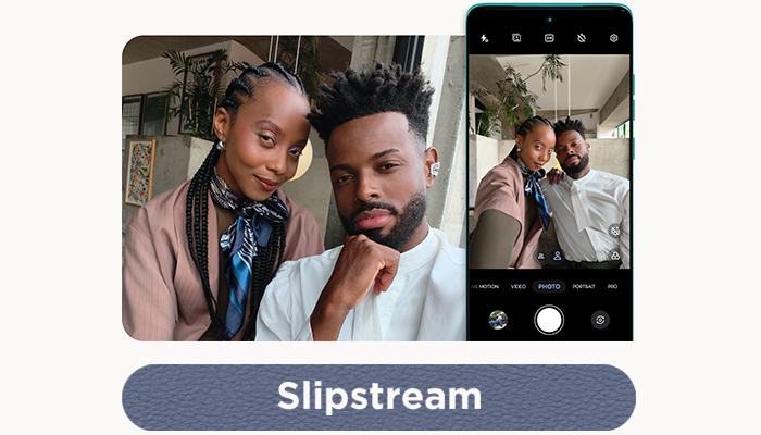 Una coppia posa per una foto. Un telefono mostra un'immagine simile con controlli della fotocamera.