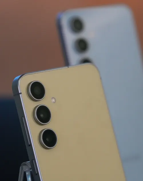 Primo piano di due smartphone con tre obiettivi della fotocamera sul retro. Uno è color oro, l'altro è grigio.