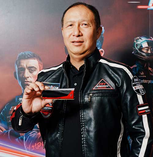 Un uomo in giacca di pelle nera mostra una tessera. Sullo sfondo, persone in tenuta da corsa.