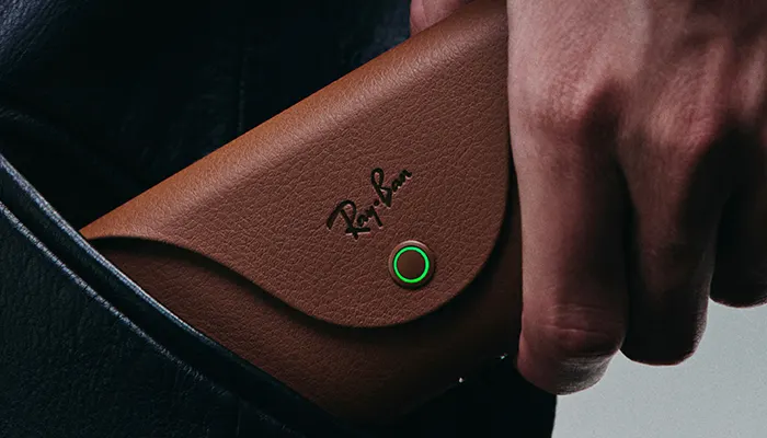 una custodia marrone deegli occhiali Ray-Ban tenuta da una mano di un uomo