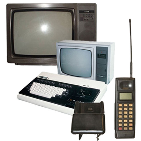 Vari dispositivi elettronici vintage: due televisori, una tastiera, un telefono cellulare con antenna.