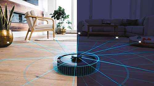Un aspirapolvere robot nero pulisce un pavimento di legno chiaro e scuro con raggi blu. Sullo sfondo si vedono mobili e piante.