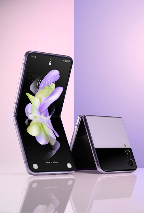 Su sfondo viola, due smartphone pieghevoli: uno aperto con schermo acceso con motivo floreale, l'altro chiuso con doppia fotocamera.