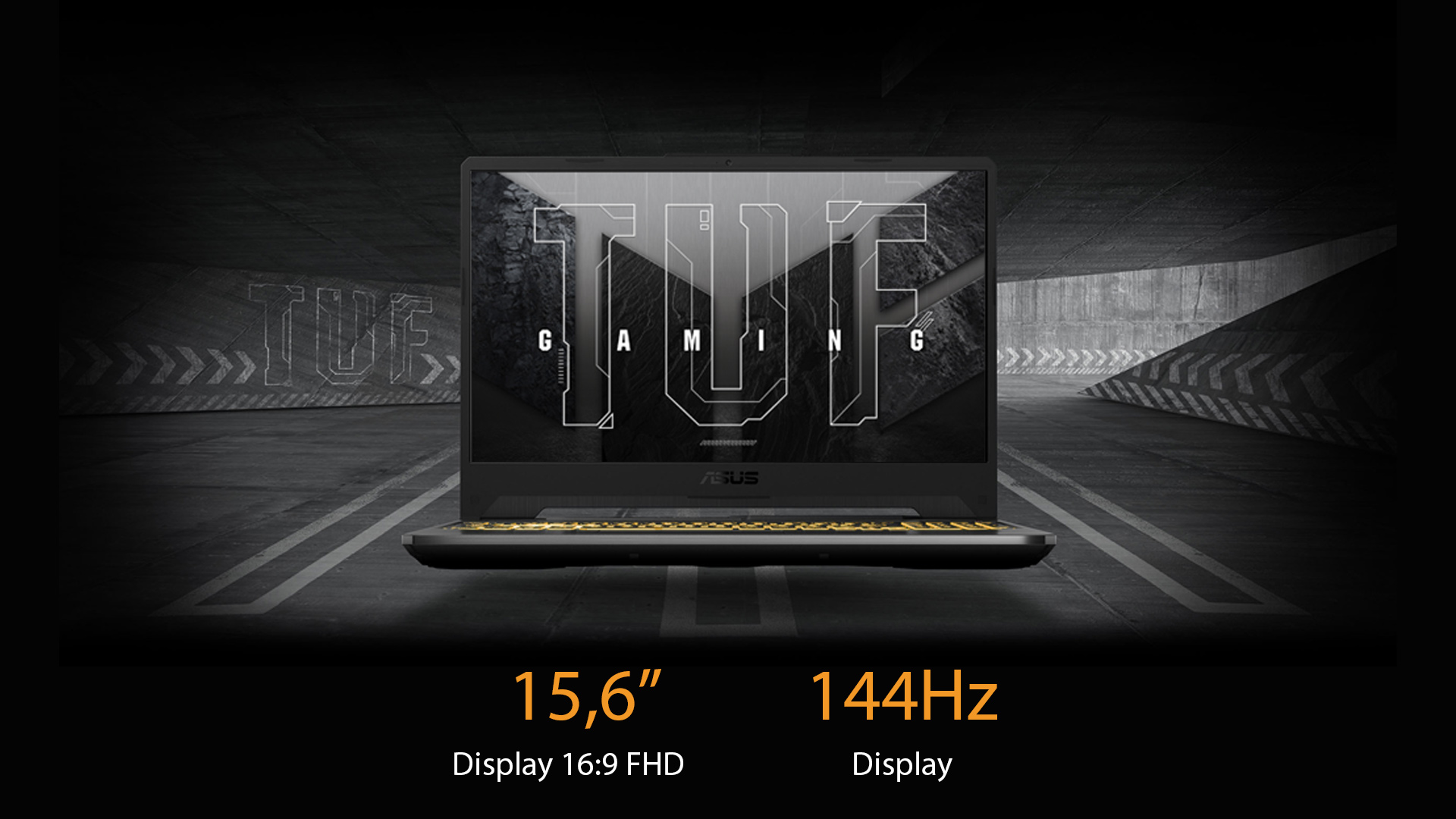 Un laptop nero aperto mostra la scritta "TUF GAMING" su uno sfondo strutturato grigio e nero. La tastiera è nera con accenti gialli.