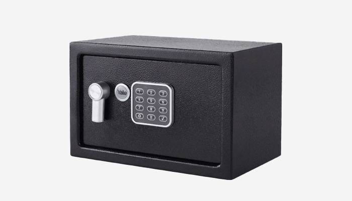 Una cassaforte nera con tastierino numerico e serratura a cilindro su sfondo bianco.