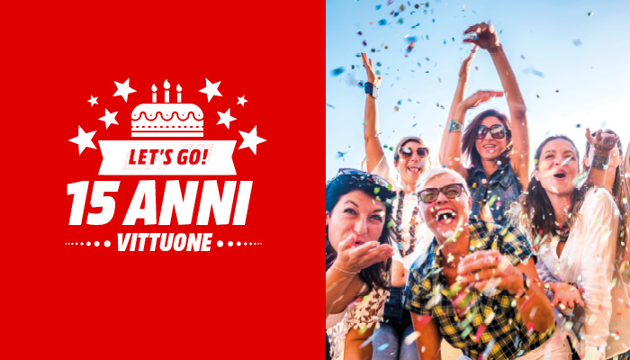 Festeggiamenti con coriandoli e logo rosso "15 Anni" con torta. Persone sorridenti celebrano sotto un cielo azzurro e festoso.