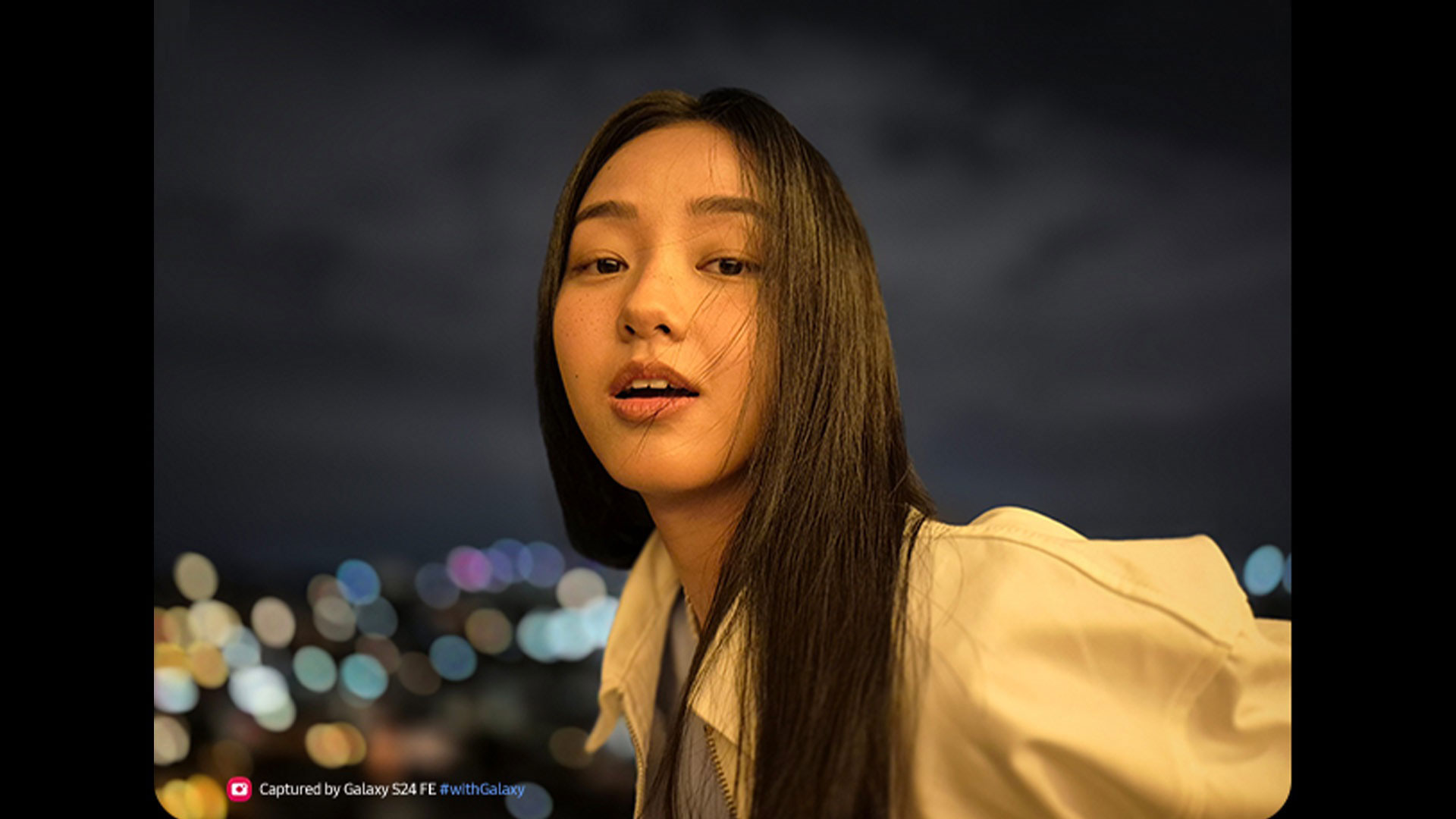 Una persona indossa una giacca chiara con luci sfocate sullo sfondo.