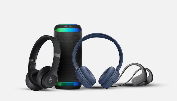 Cuffie nere, blu e grigie con altoparlante cilindrico nero con luci colorate su sfondo bianco.