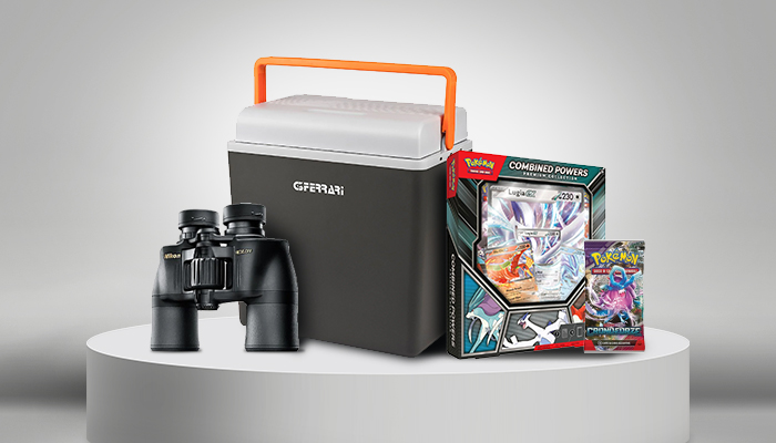 Binocolo nero, borsa frigo grigia con manico arancione e confezione di carte Pok�mon su una piattaforma bianca.