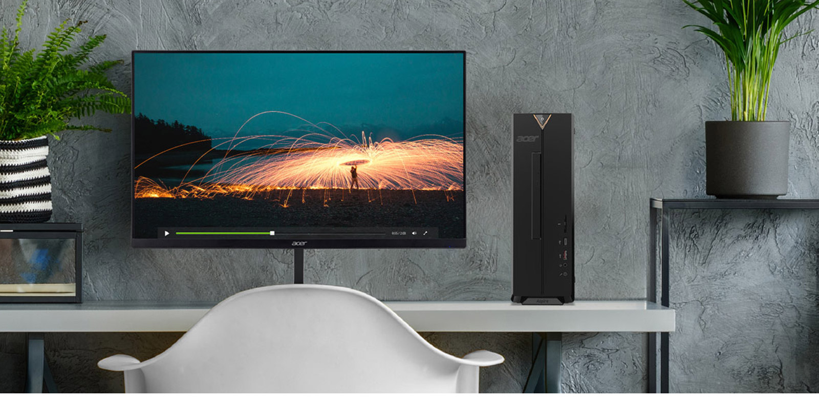 Monitor con grafica, computer nero, piante in vaso su mobile bianco e sedia bianca.