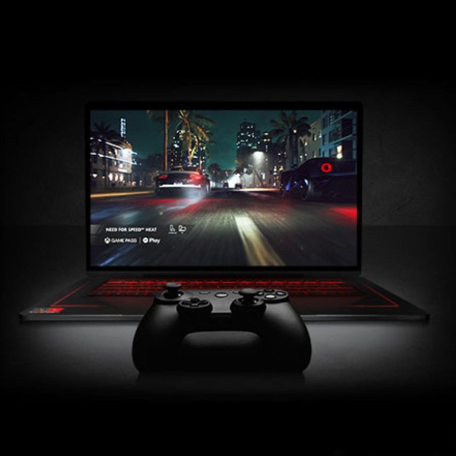 Un computer portatile mostra un gioco di corse automobilistiche, con un controller di gioco in primo piano e tastiera rossa.