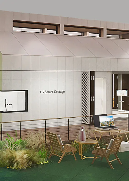 Cottage bianca con finestre, tavoli e sedie in legno su prato verde. Un portatile � su un tavolo.