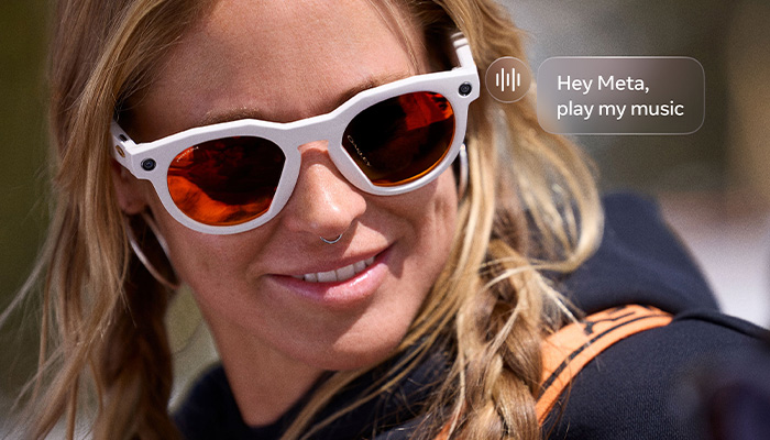 una ragazza con degli occhiali Meta Oakley. Una scritta con "Hey Meta, play my music"