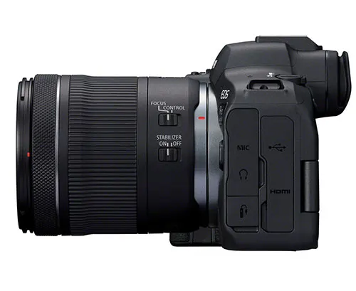 Una fotocamera nera con un obiettivo grande, rivolta verso sinistra, su uno sfondo bianco.