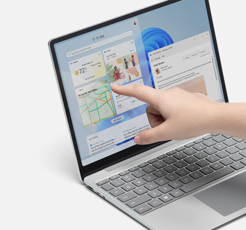 Un computer portatile aperto mostra un'interfaccia utente con una mano che interagisce con lo schermo.