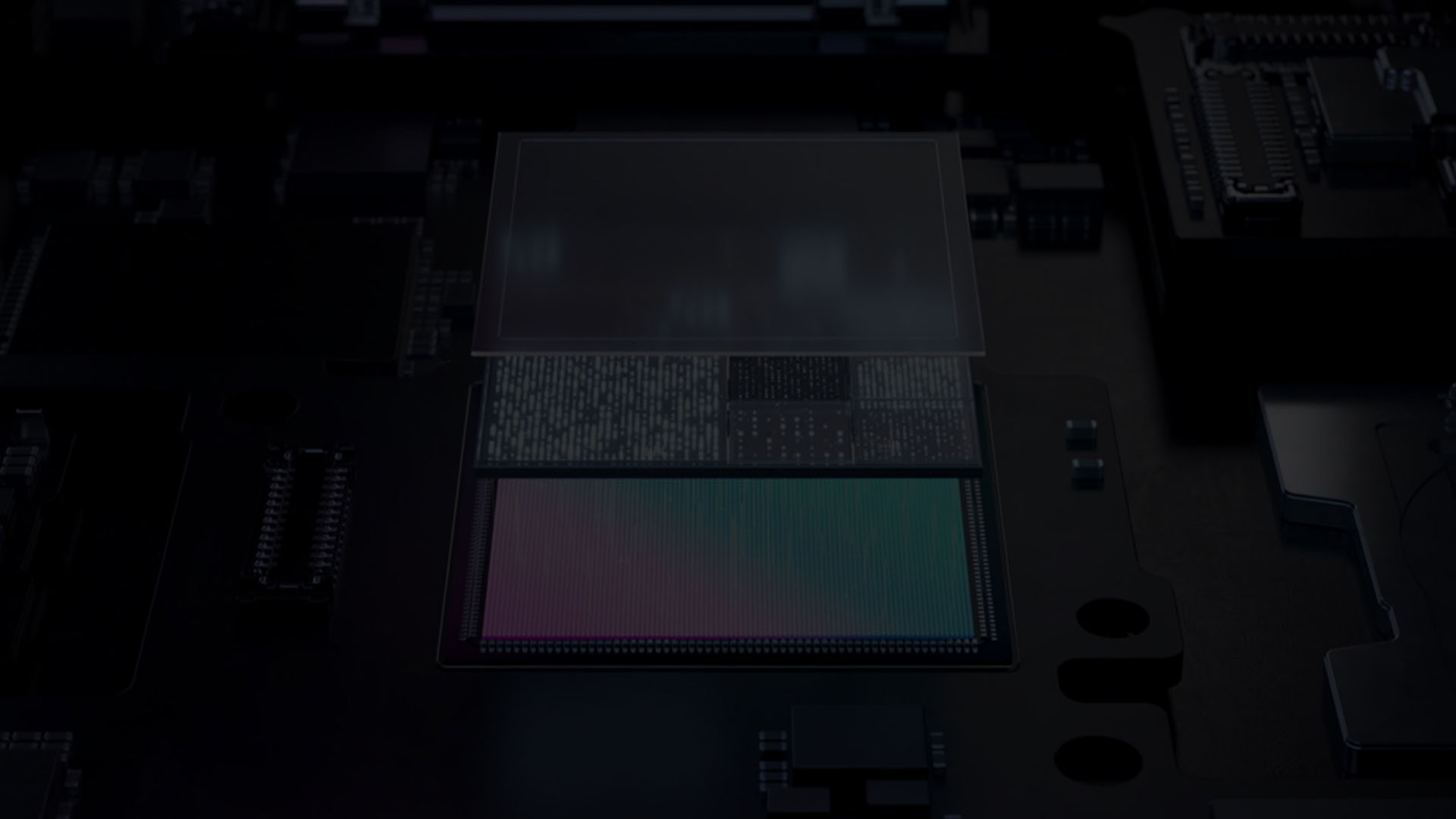 Primo piano di un microchip con componenti verdi e rosa su sfondo nero.