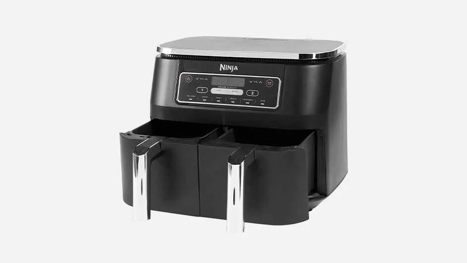 Een zwarte Ninja airfryer met twee manden en zilveren handvatten tegen een witte achtergrond.