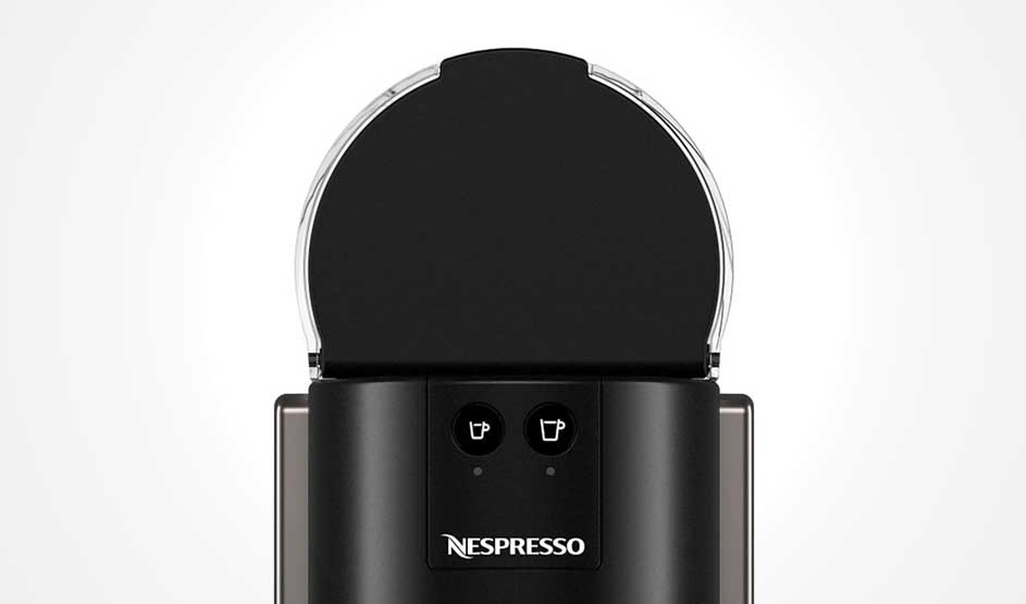 Op de afbeelding zie je een zwarte koffiemachine van het merk Nespresso met twee knoppen voor verschillende kopgroottes boven het logo.