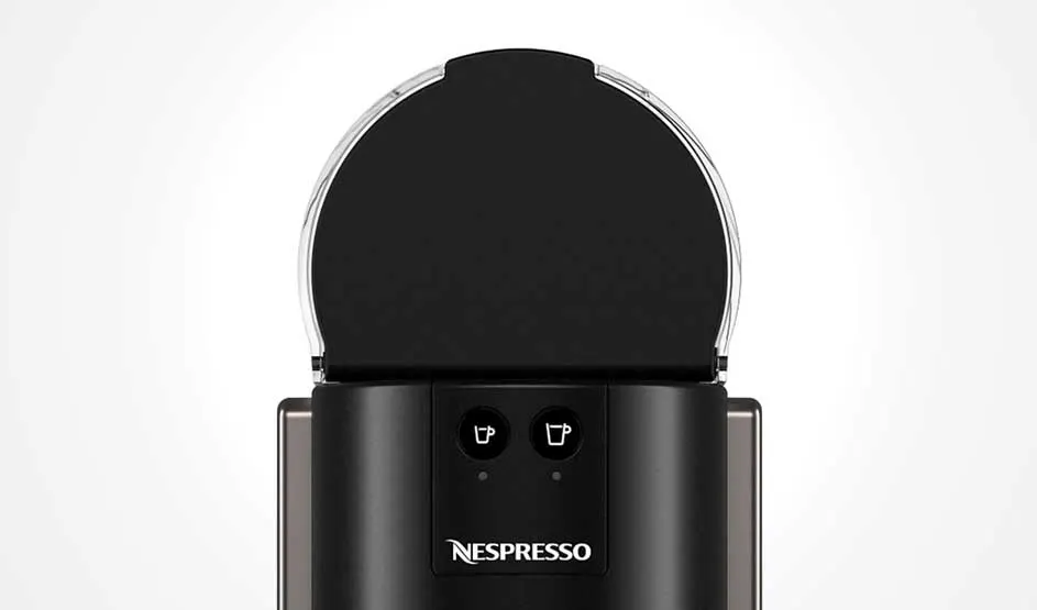Op de afbeelding zie je een zwarte koffiemachine van het merk Nespresso met twee knoppen voor verschillende kopgroottes boven het logo.