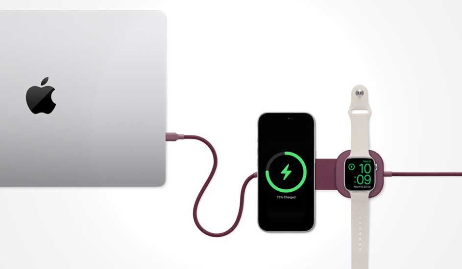 A MacBook links to a charging pad where an iPhone and an Apple Watch power up together, connected with matching purple cables.