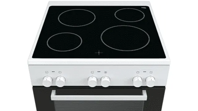 Wit fornuis met vier zwarte kookzones en een oven met een handgreep. Bedieningsknoppen aan de voorkant.