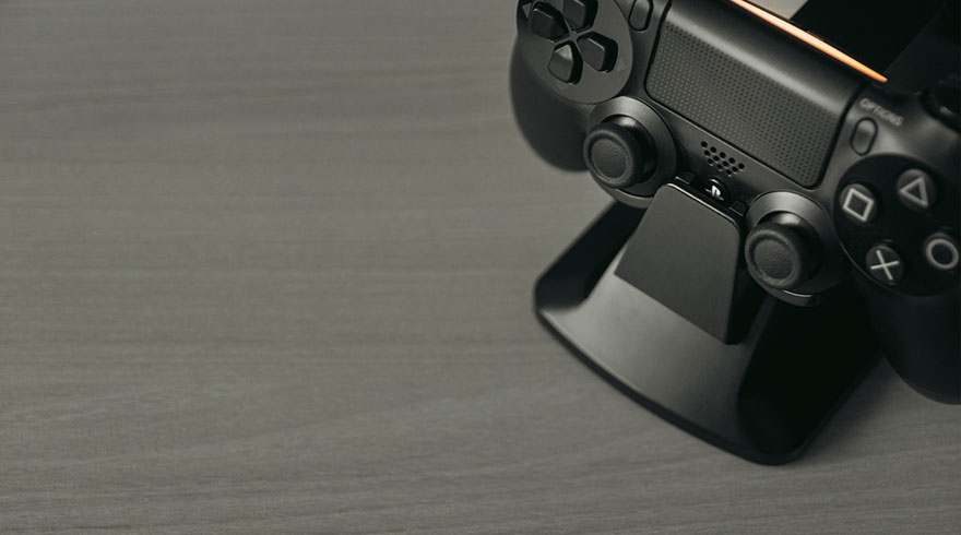 Zwarte PlayStation-controller op een zwart oplaadstation tegen een grijze achtergrond.