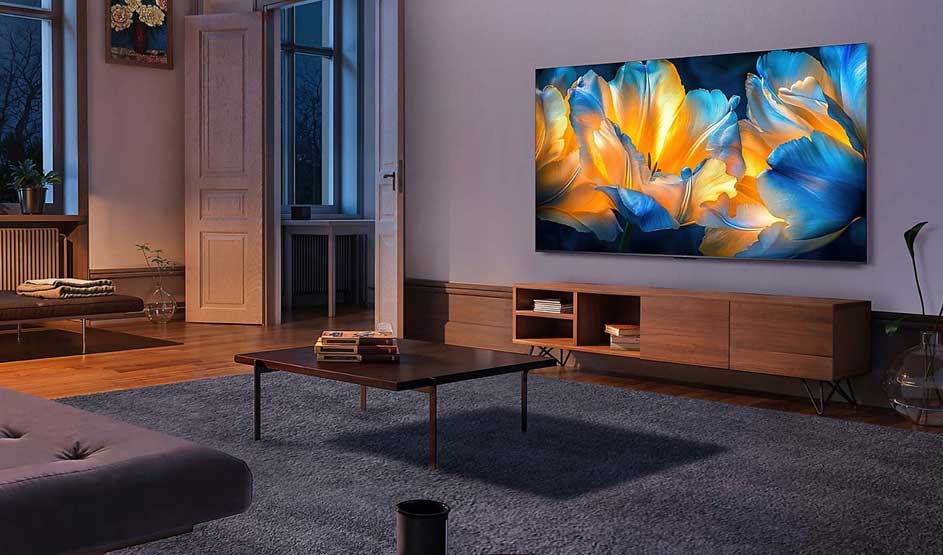 In een stijlvolle woonkamer hangt een grote tv boven een houten kast; op het scherm bloeien lichtende blauw-oranje bloemen.