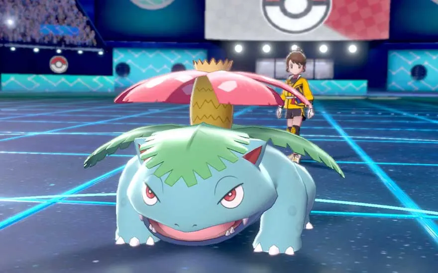 A large green Pokémon with a pink flower on its back crouches on a glowing battle arena, while its young trainer stands watch behind.