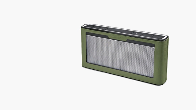 Een groene Bluetooth-luidspreker staat rechts tegen een witte achtergrond, met een zilveren rooster en zwarte knoppen bovenop.